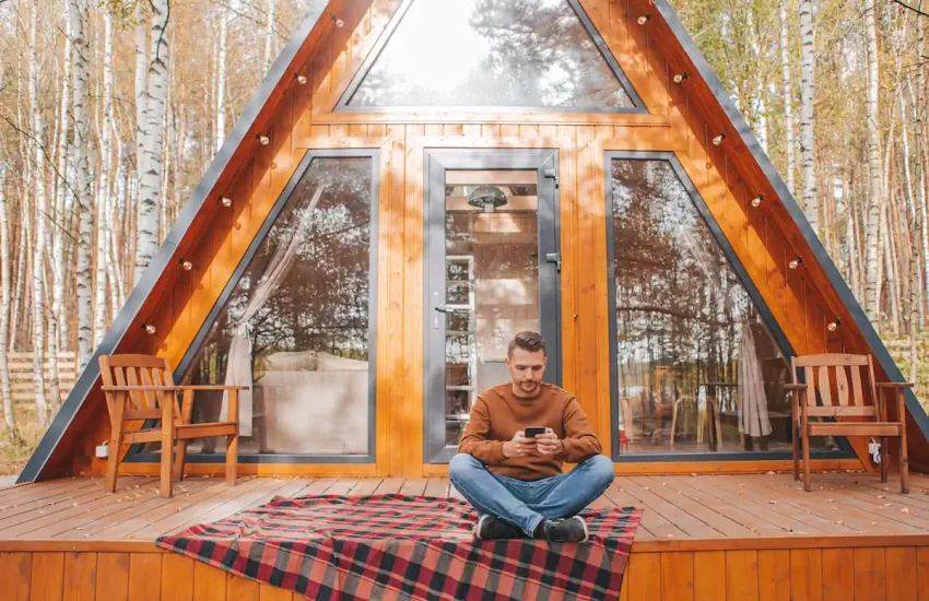 Un homme devant un chalet en bois