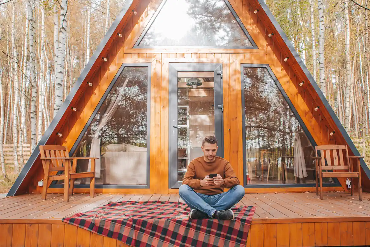 Un homme devant un chalet en bois