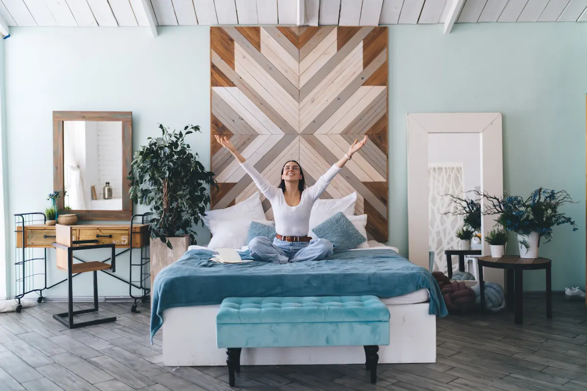 Une femme assise sur un lit avec au milieu de la pièce