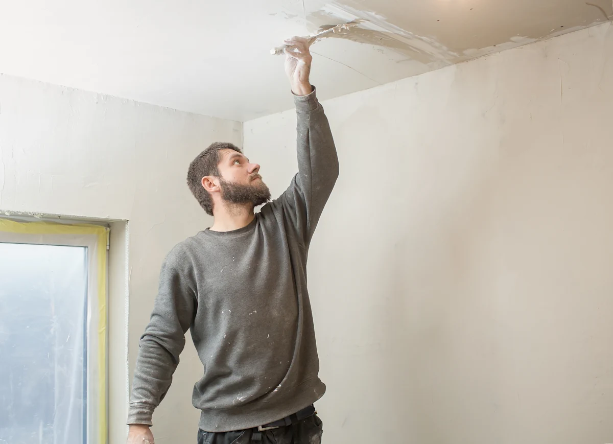Un homme qui rénove le plafond