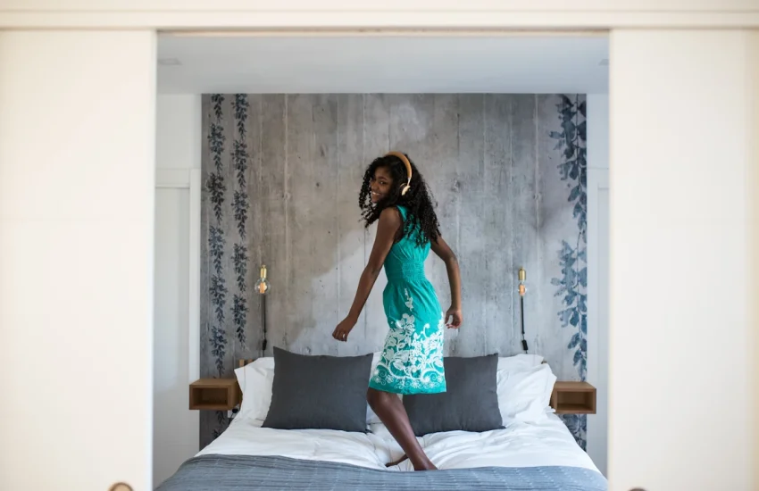 Une jeune fille qui danse sur un lit