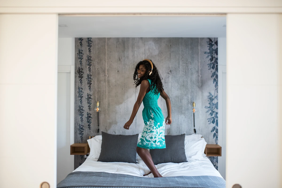 Une jeune fille qui danse sur un lit
