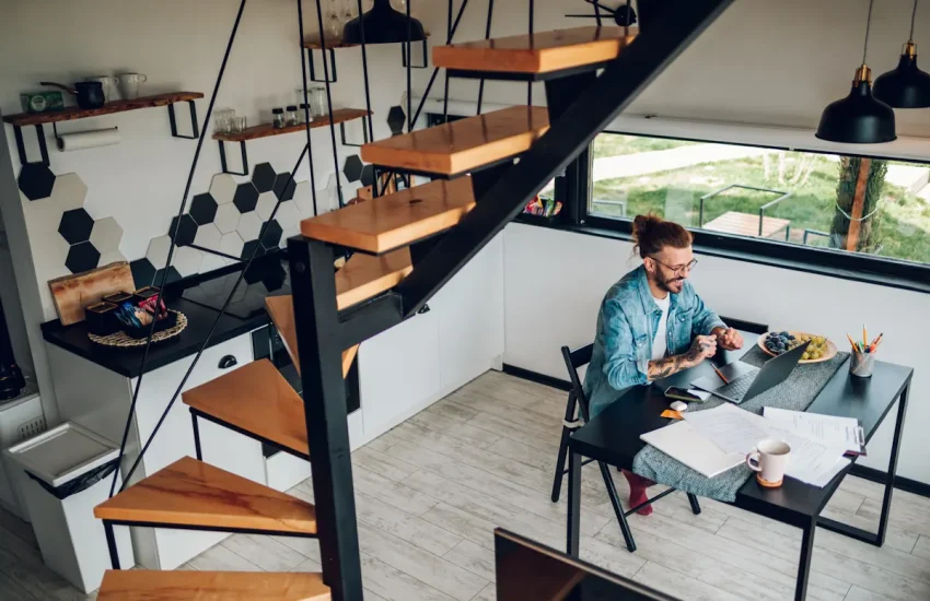 Un homme qui travaille sur un bureau sous un escalier