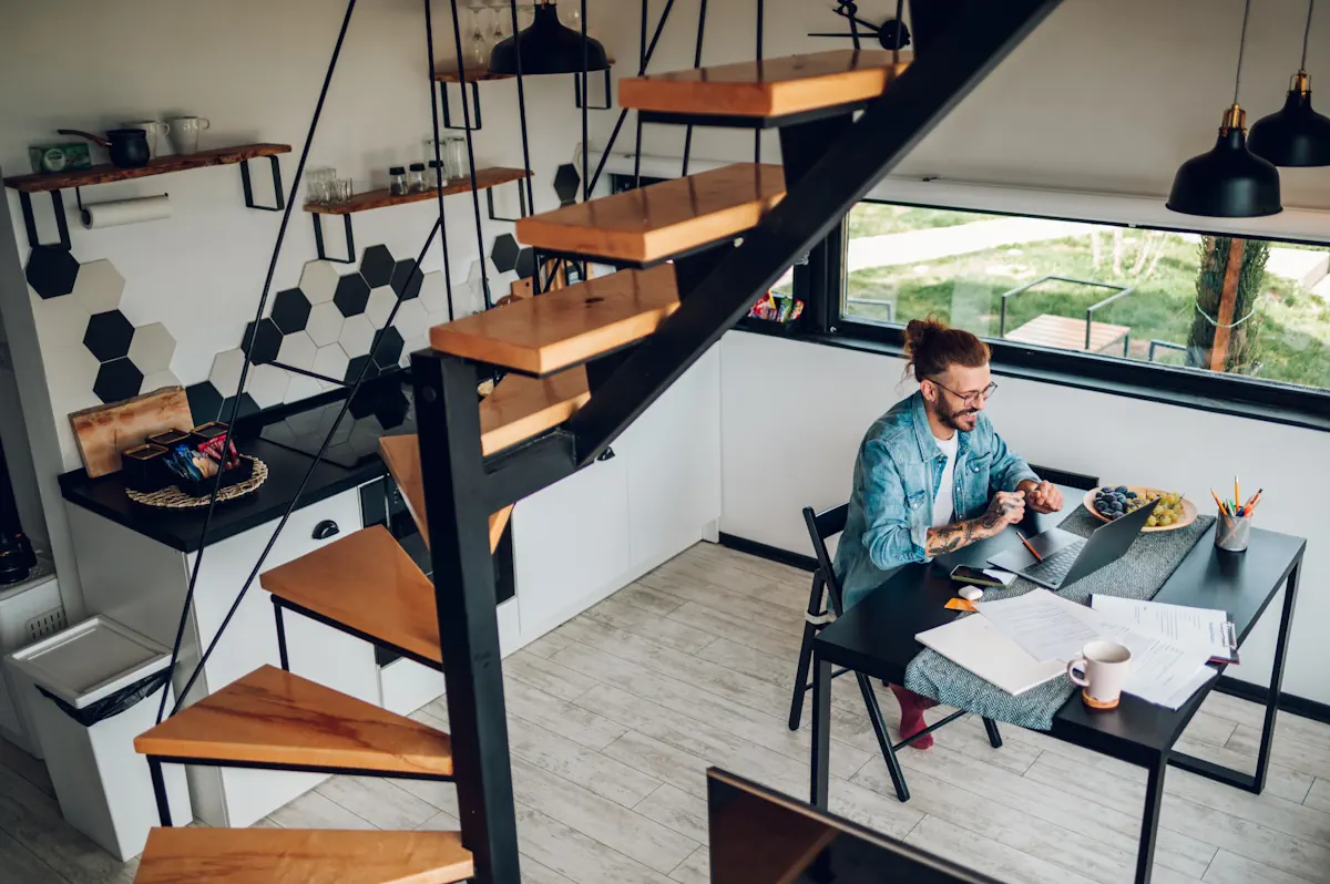 Un homme qui travaille sur un bureau sous un escalier