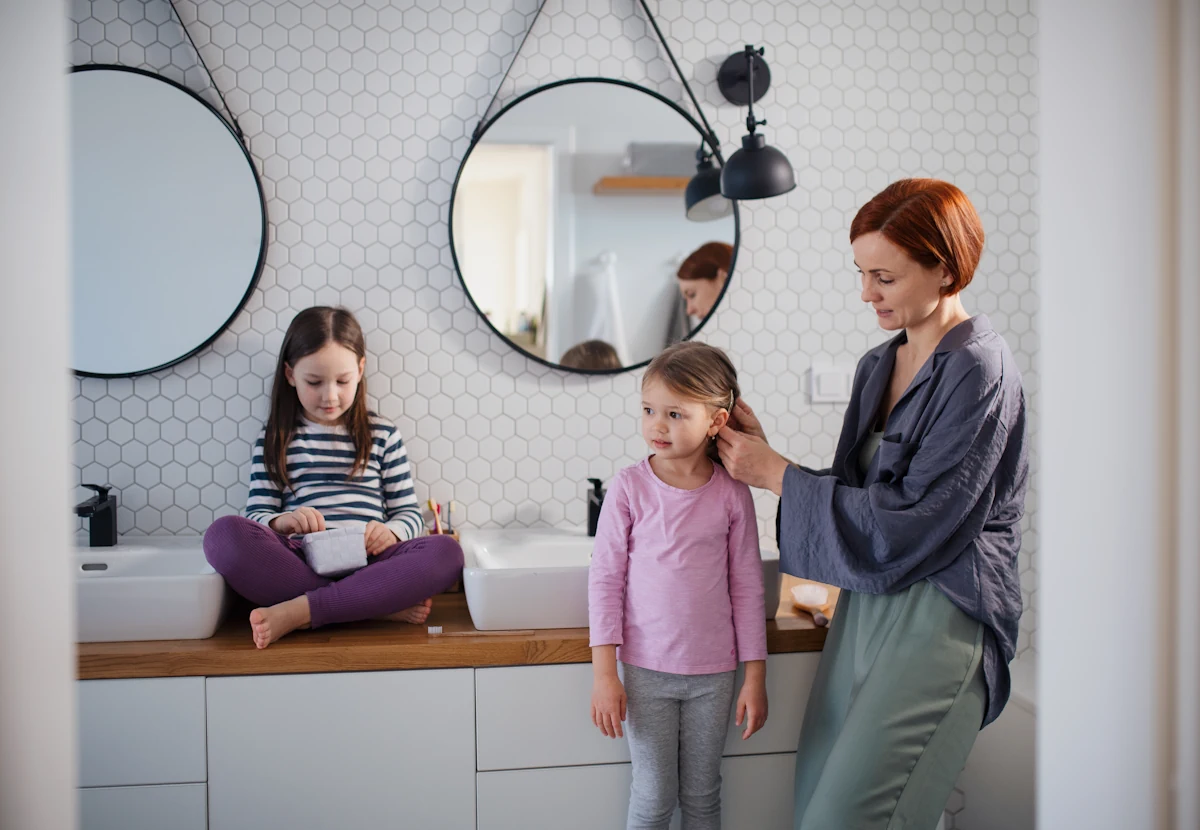 Une femme avec deux enfants dans une salle de bain