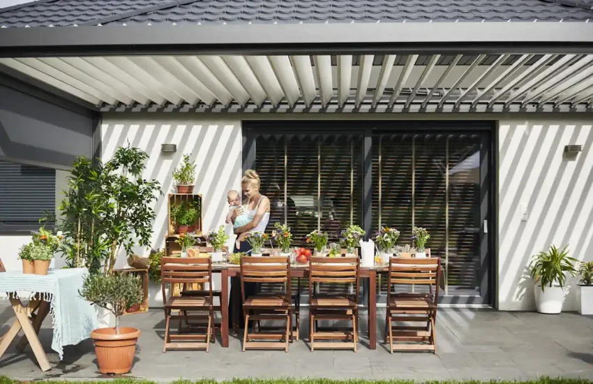 une femme avec un bébé sous une véranda alu