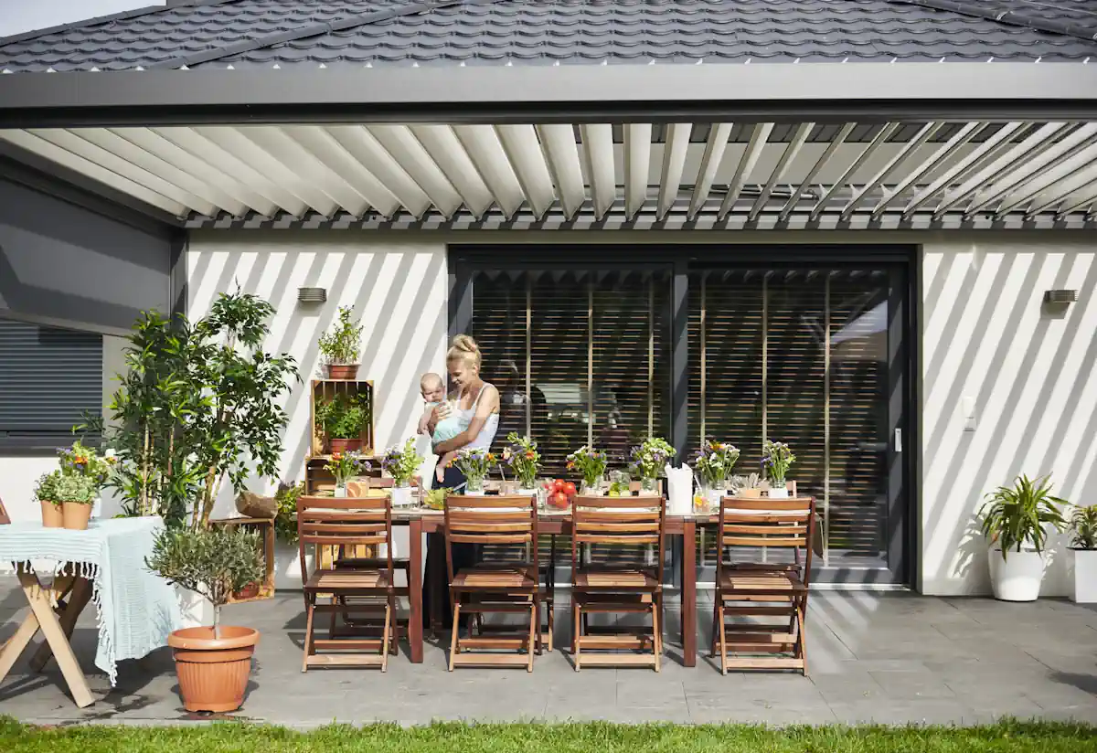 une femme avec un bébé sous une véranda alu