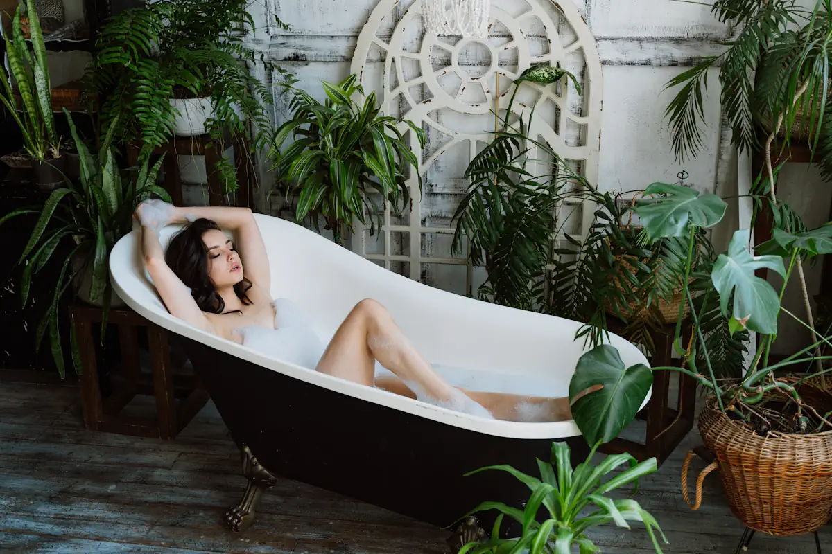 Une femme dans une baignoire entourée de plantes vertes